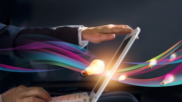 Imagen de una señor usando una laptop, y un foco en medio representando las ideas.